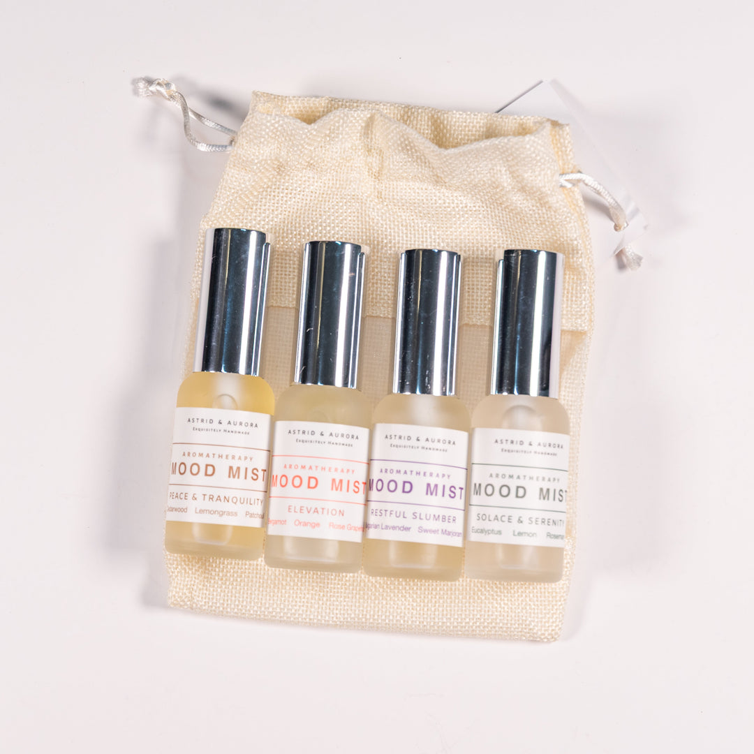 Four bottles of aromatherapy with silver caps atop a canvas bag