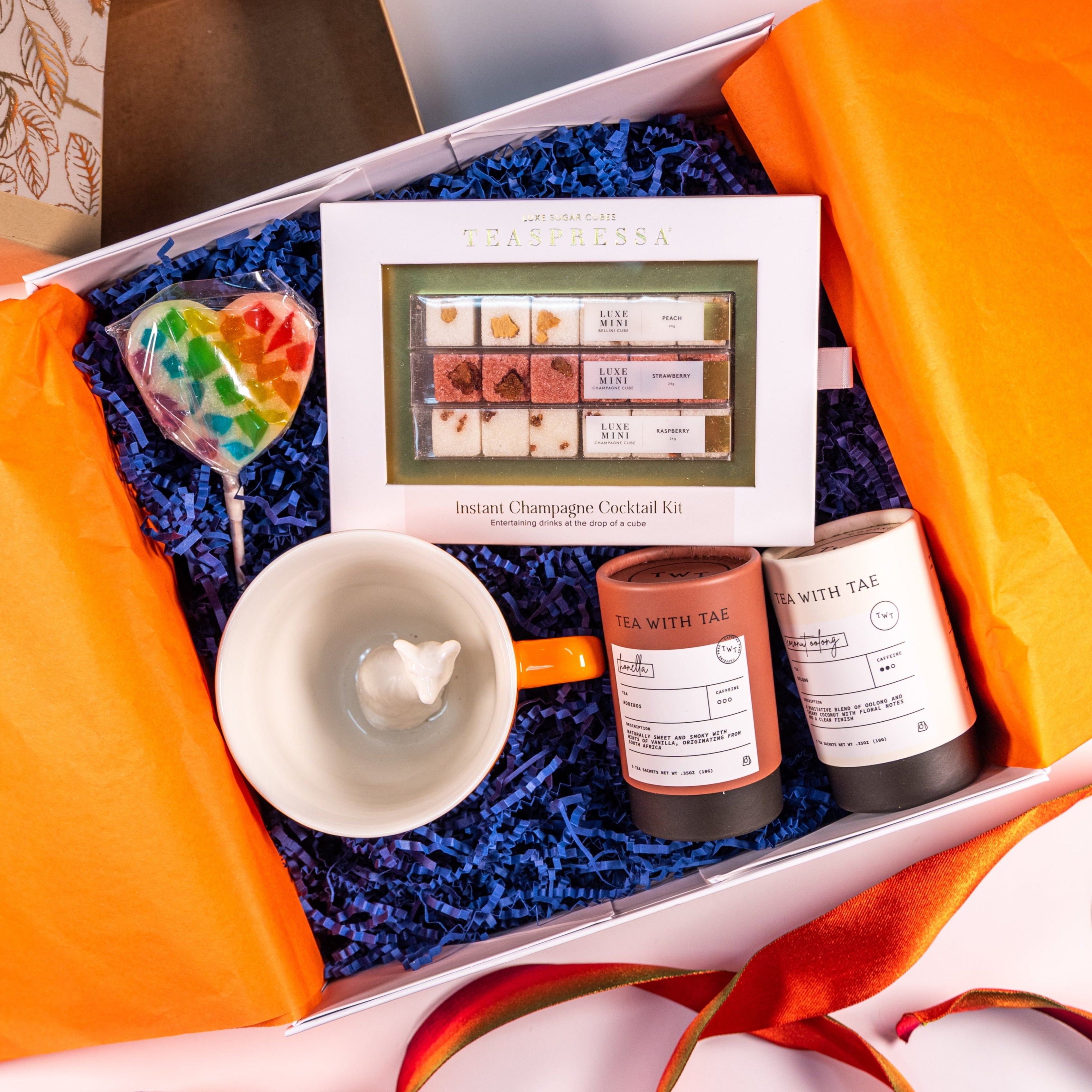 An open decorative box with three tea and drink gifts