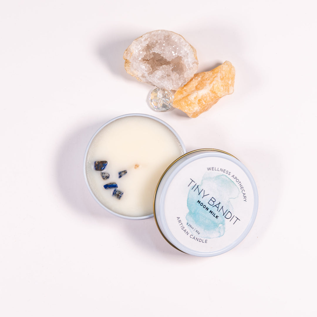 Candle in a tin with decorative elements in the background