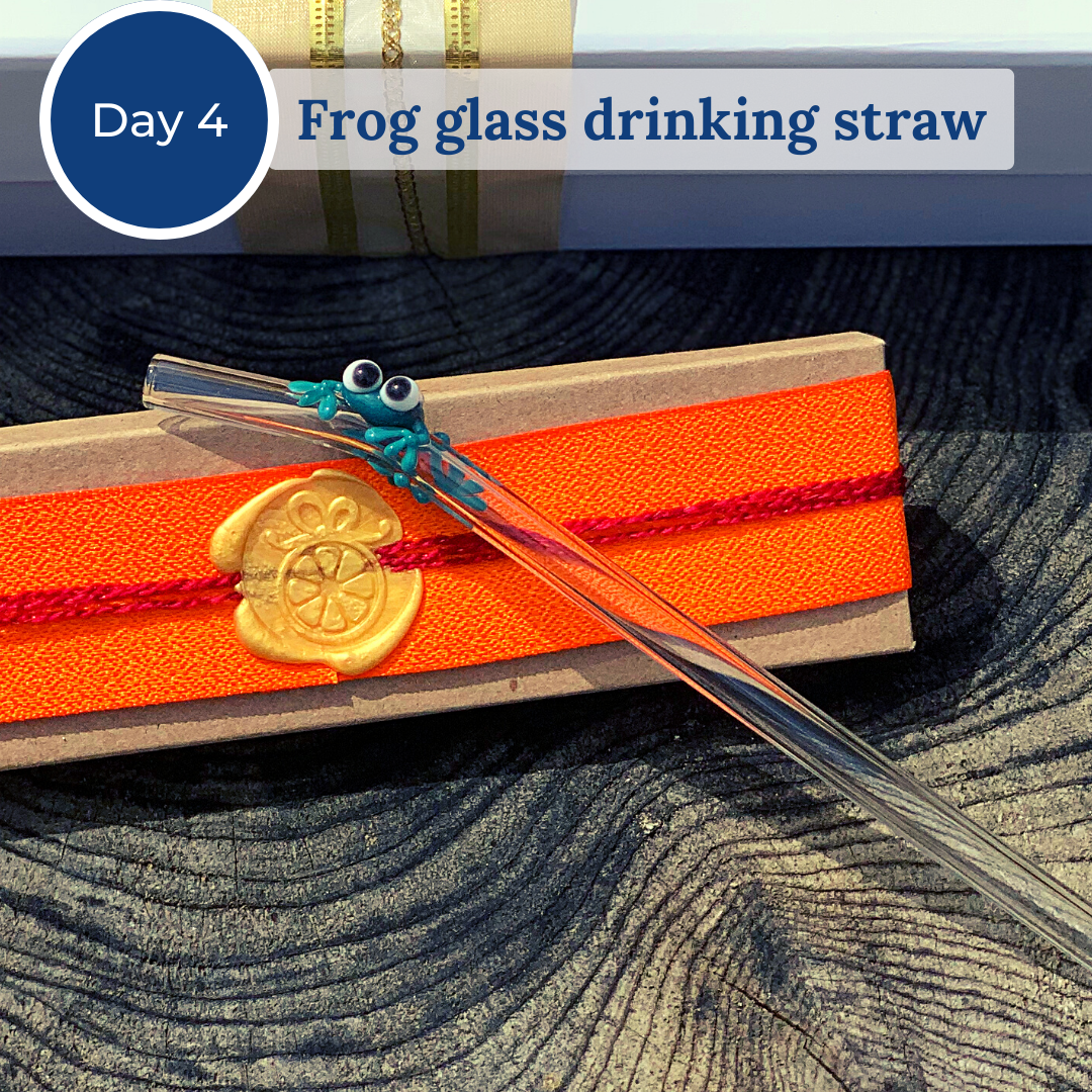 Glass drinking straw with a small green glass frog attached