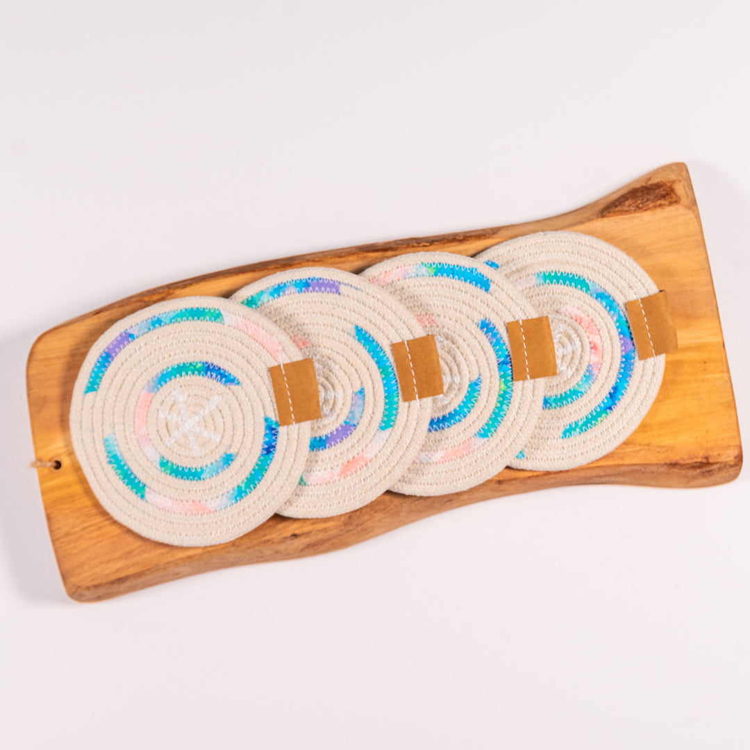 Set of circular coasters with colorful patterns on a wooden tray against a white background
