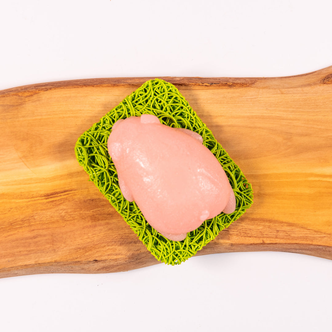 A pink pig jelly soap atop a green soap rest