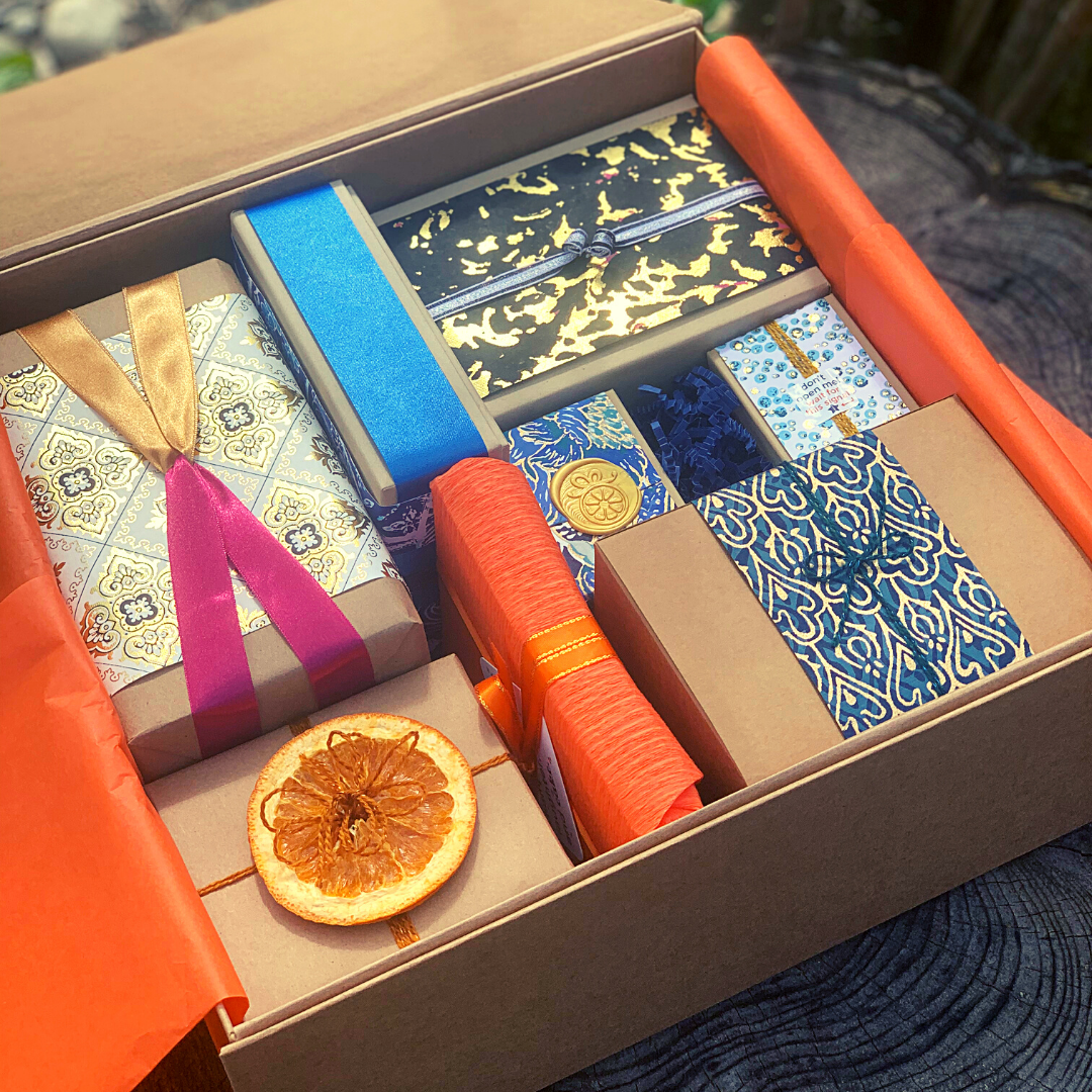 An open gift box displaying eight hand-wrapped gifts